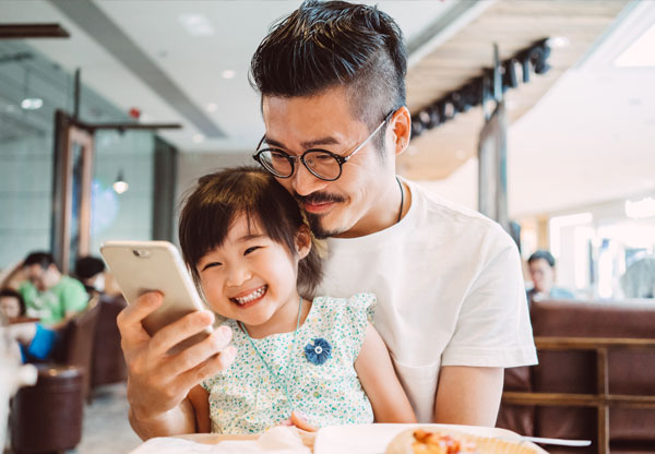 Two women looking at cell phone smiling