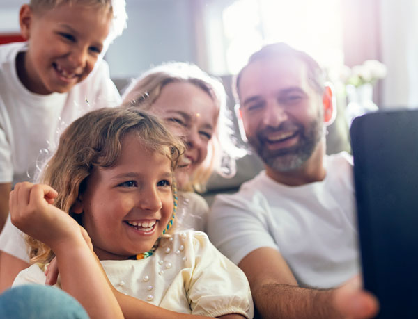 A family captures a selfie with their cell phone.